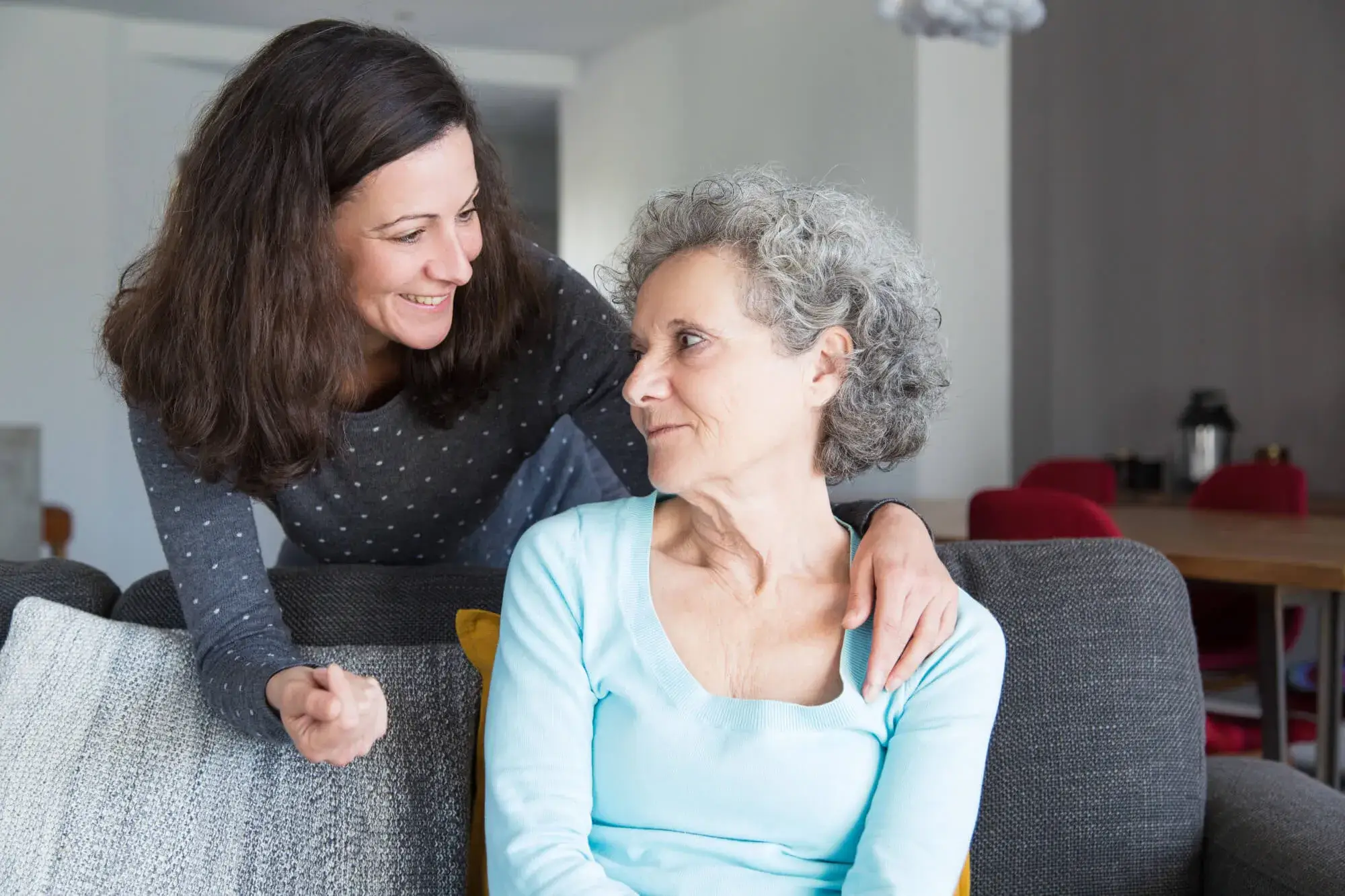 a young woman looking at her elderly mother